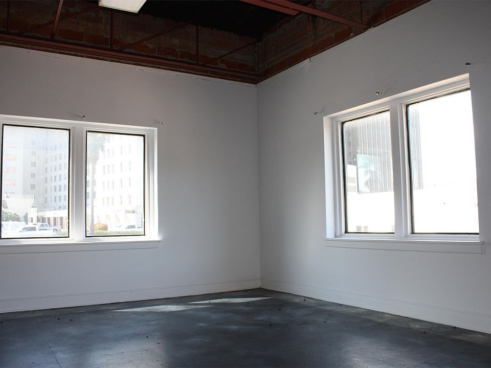 Large office area with views overlooking downtown and exposed ductwork and trusses in the ceiling.