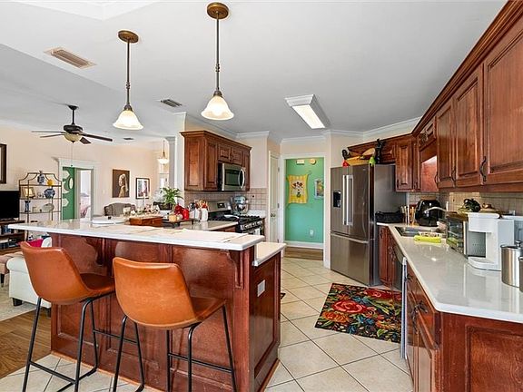 Kitchen featuring visible vents, a peninsula, a breakfast bar, stainless steel appliances, and backsplash