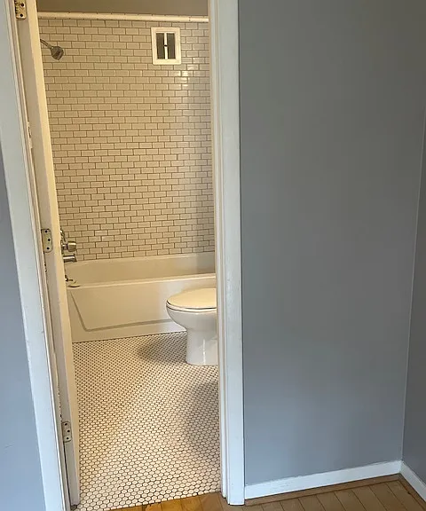 Bathroom has newer tile floor and subway tile shower/tub surround.