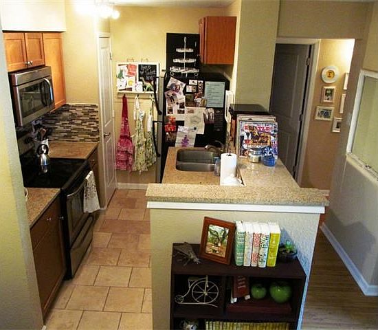 Travertine floors in kitchen, granite countertops, glass backsplash, stainless appliances