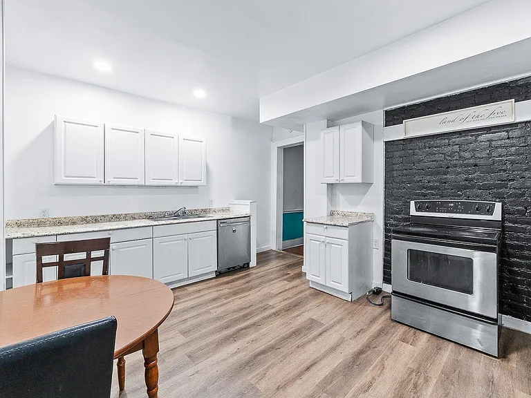 Spacious eat-in kitchen with ample cabinet storage, granite-look counters, dishwasher, and electric range for easy cooking.