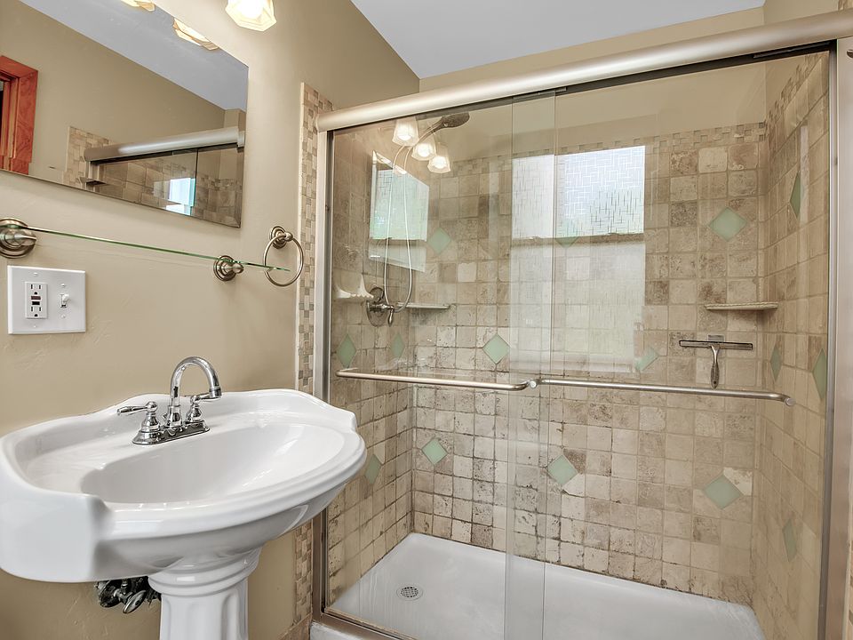glass shower with tile and pedestal sink