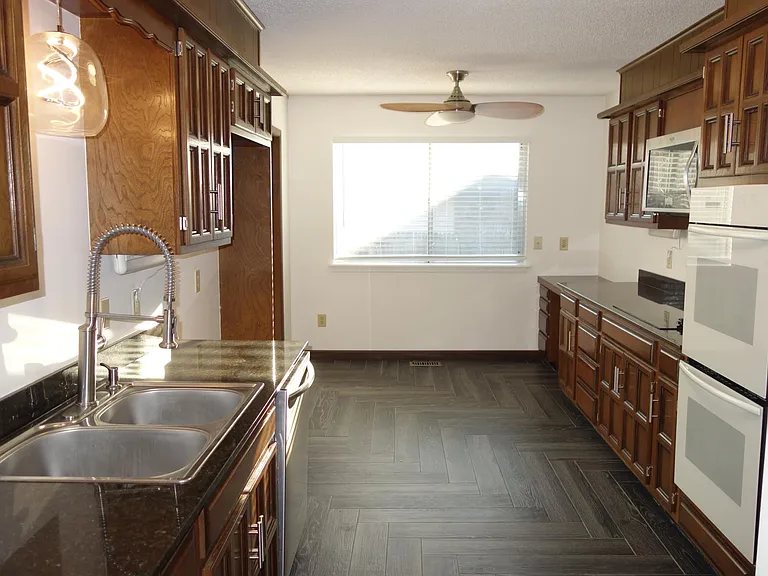 Spacious galley kitchen with double basin sink and lots of prep space. Smooth cooktop and double ovens!
