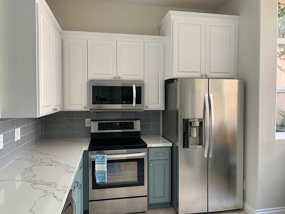 Two toned cabinets and stainless steel appliances.