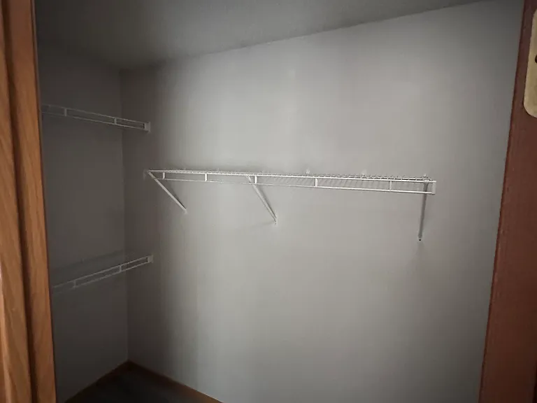 Walk-in closet with built-in shelving off the primary bedroom