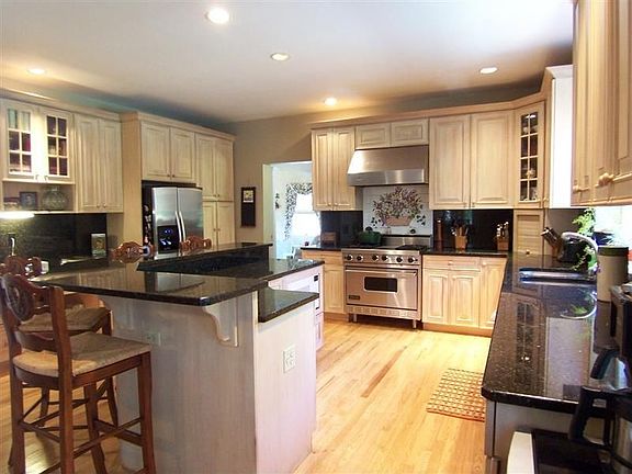 Kitchen with huge 2-level center island topped with granite & SS appliances