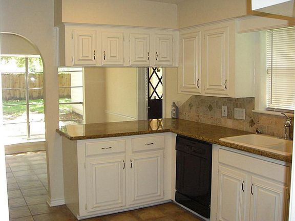 Kitchen features granite counters and tile backsplash