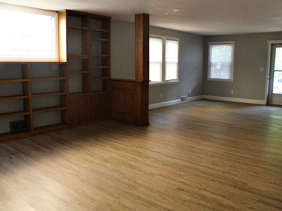 Massive main room/dining room with built-in bookshelf and stained glass window