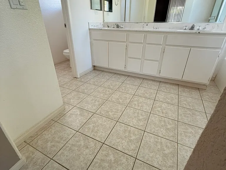 Bathroom in primary room. Tub, shower, two sinks, separate room with toilet.