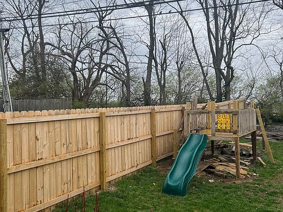 Backyard with new privacy fence, and playhouse.