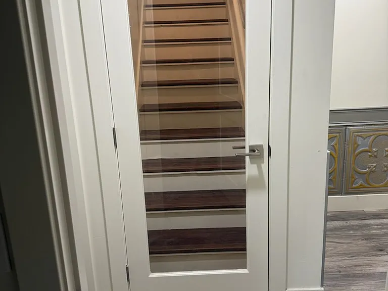 Tempered glass door leads to loft style bedroom, only bedroom with carpet.