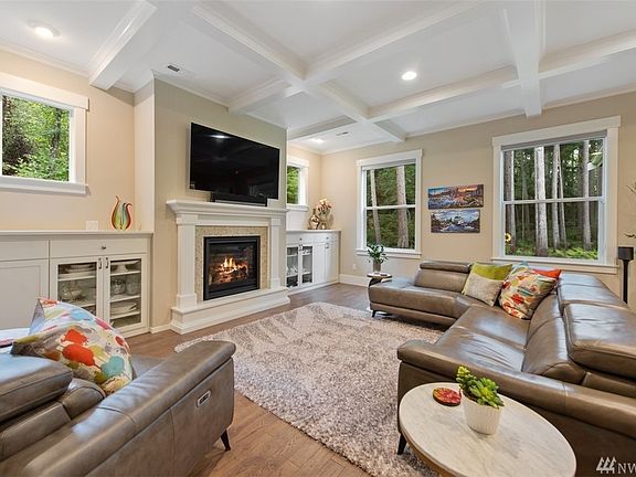 The great room features beautiful architectural styling such as the box beam ceiling, hardwood floors, built in cabinets and the warm and inviting  fireplace!