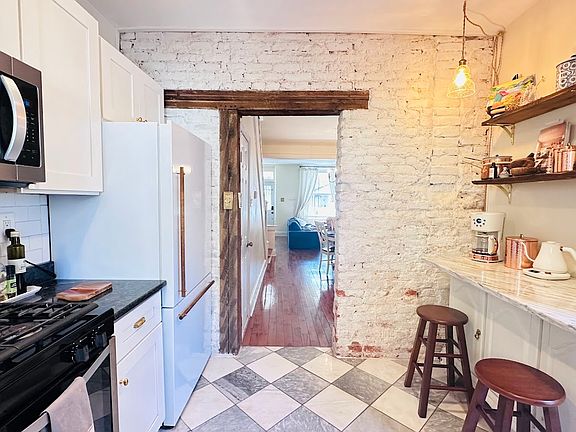 Real marble floor, exposed brick and 100 year old original wood beams with an eat in kitchen counter and coffee bar.