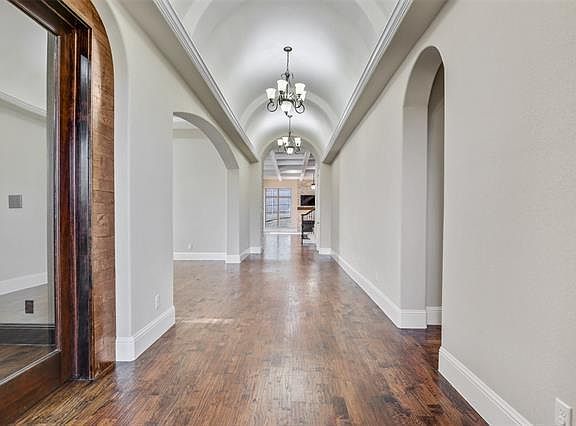 Entry hallway with high arches and chandeliers.