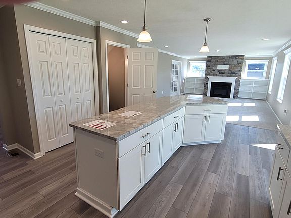 Kitchen open to the Family Room with Stoned Fireplace and Bu