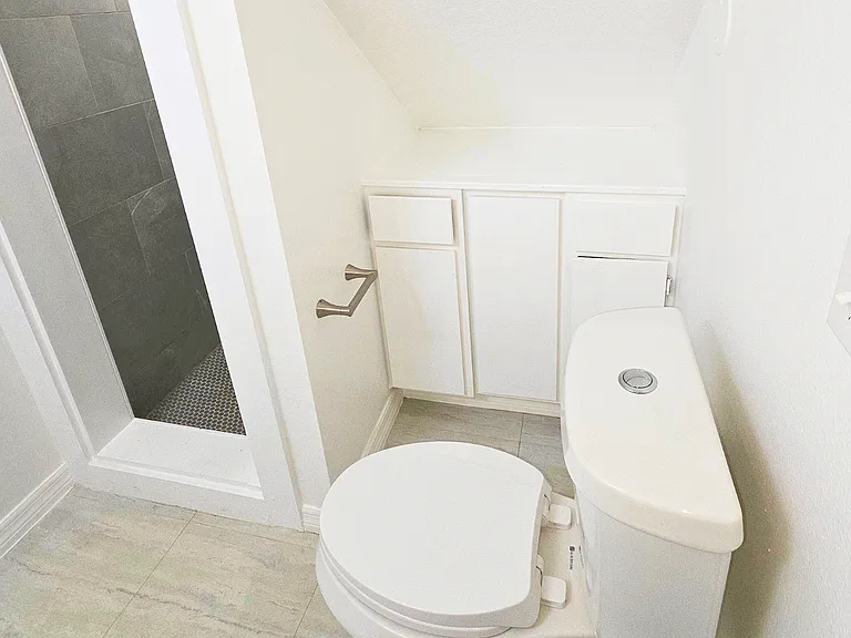 Spotless powder room with built-in cabinets for extra storage