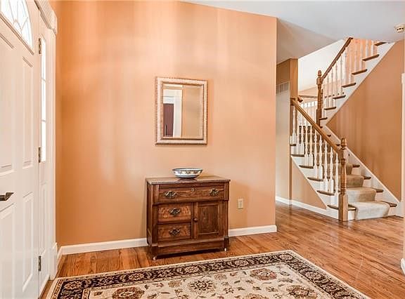 Large entrance foyer with open staircase to second floor greets guests