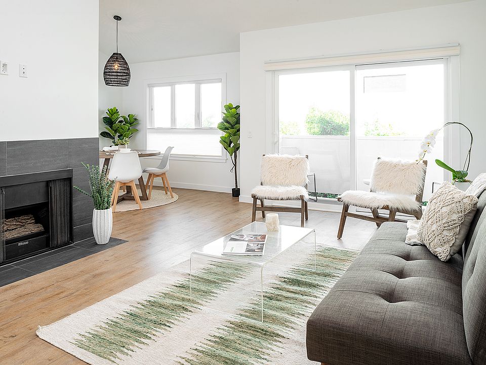 Living room with fireplace leading to balcony and dining room