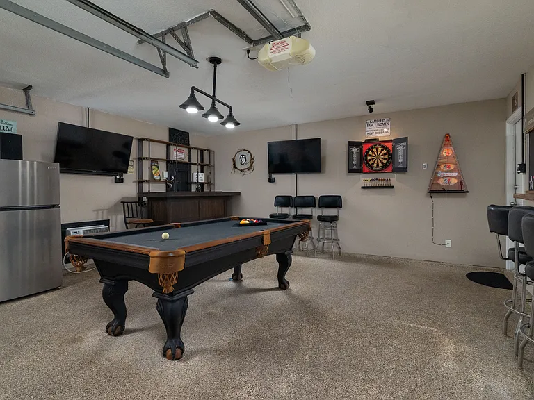 AMAZING game room featuring a pool table, fridge/freezer, full bar with bar tools & bar stools, 2 flat-screen Roku TVs, electronic bags game, darts, and air conditioning unit _ the perfect space to kick back, entertain, and make lasting memories.