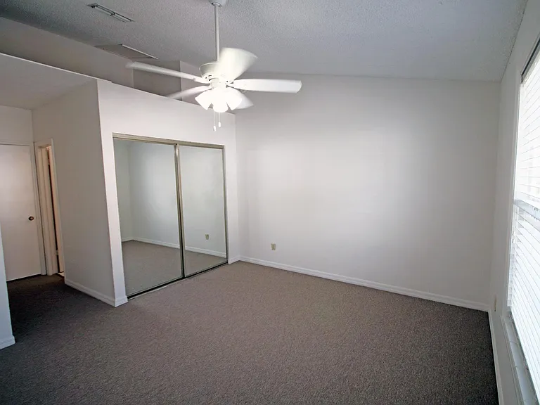 Front bedroom with two closets, vaulted ceilings and ceiling fan.