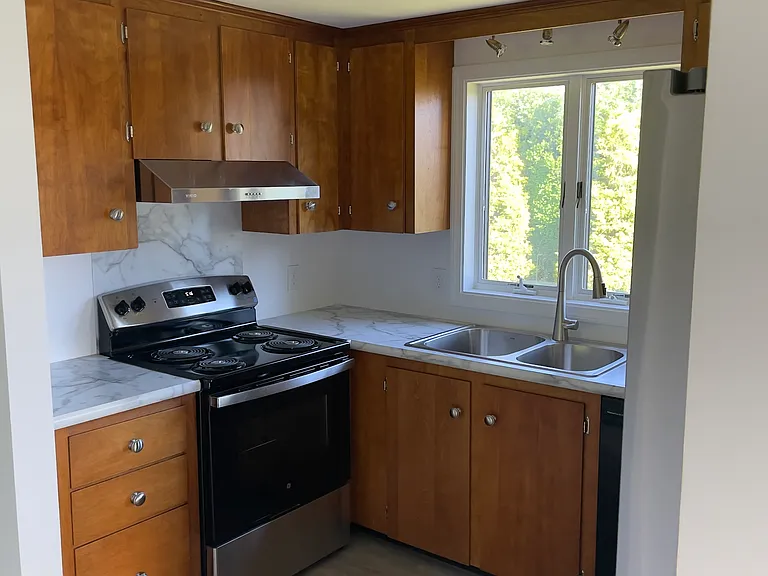 New range, range hood, kitchen sink and faucet, countertops, floor and refrigerator.