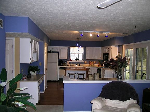 Large open kitchen with a center island and room for a breakfast table. Newly refinished cabinets, flooring, and specialty lighting. Planning desk and gas range.