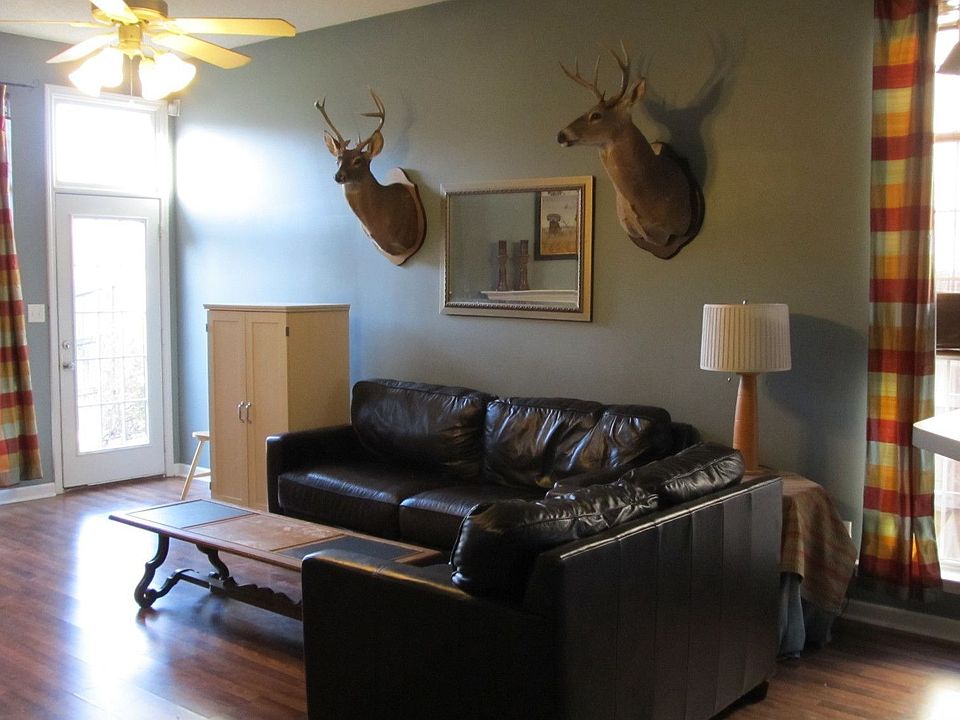 Greatroom has fireplace, high ceiling, wood floors, and larger than average.