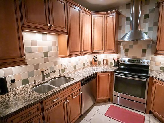 Updated kitchen with custom cabinets, granite countertops, stainless appliances, and tile floor.