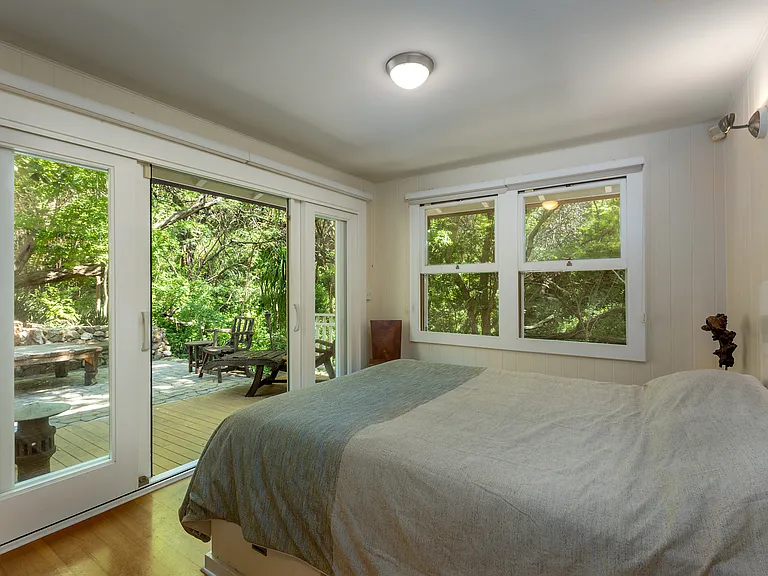 Second bedroom on the main floor has a king bed with large slider open to outdoor patio