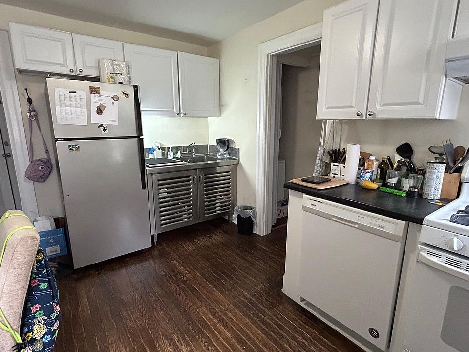 Eat in kitchen with gas range, dishwasher, stainless steel restaurant grade sink & cabinet, and silver refrigerator. Shelving unit (not in photograph) available for tenant's use for under the high cabinets.