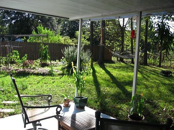 Back patio, fully fenced yard, organic garden, hammock and field.