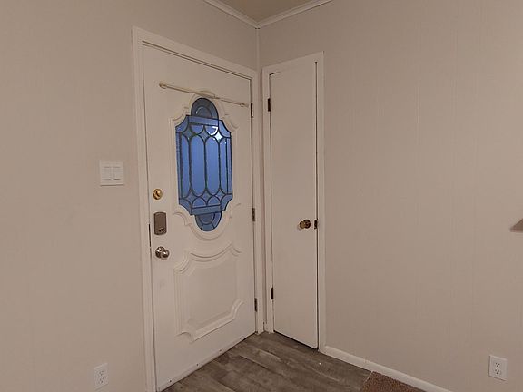 Entry door next to small coat closet