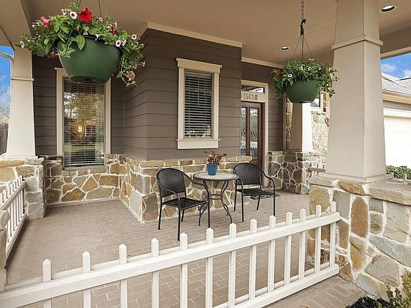 Inviting front porch with brick-laid tile and flagstone exterior accents.
