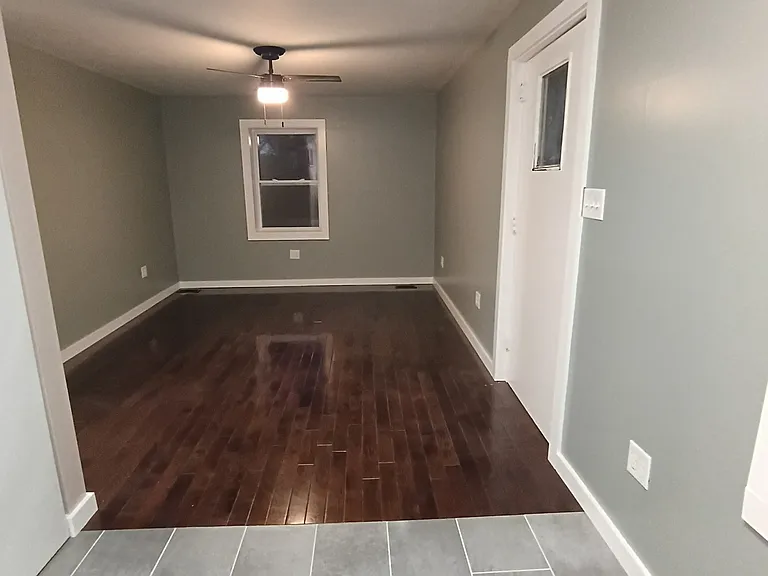 living and dining rooms open floor plan
with new large format tile and brand-new hardwood floors new celling fan and windows