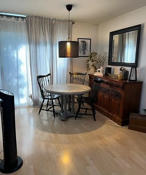 Dining room leading into kitchen with balcony entrance.