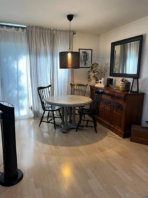 Dining room leading into kitchen with balcony entrance.