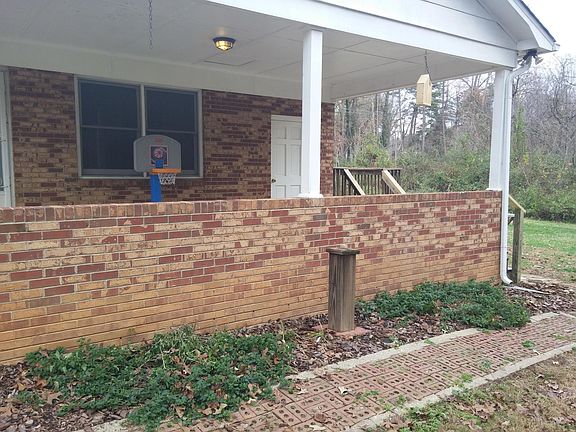 Roofed carport with interior access thru kitchen and laundry room, along with steps leading to the back yard and large wood deck.