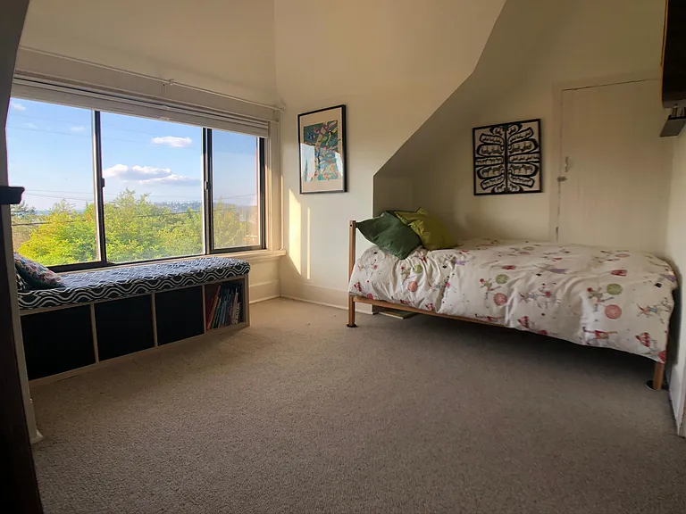 Smaller upstairs bedroom. Oversized window with peek-a-boo views of Lake Washington.