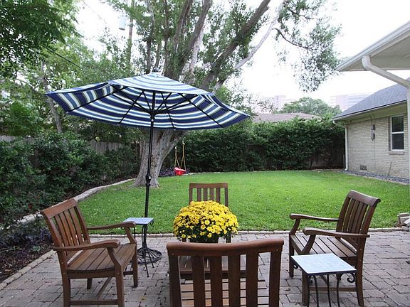 Large backyard with privacy hedge