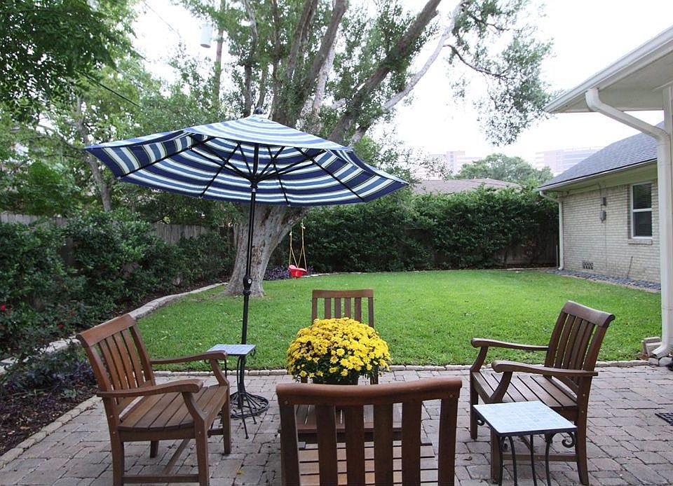 Large backyard with privacy hedge