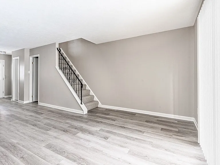 Interior of living/dining area in apartment home with faux wood flooring & without corner fireplace