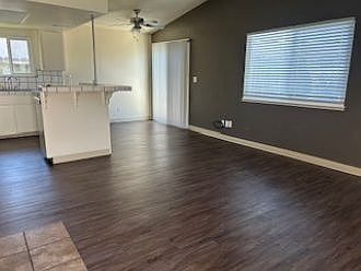 Dining area with fresh paint, accent wall, vinyl plank flooring, ceiling fan, and sliding door to patio