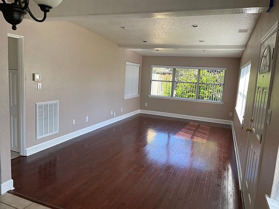 1 of 2 pics of Living Room. approx. 20' x 12'. Room has vertical blinds and recessed lighting.
