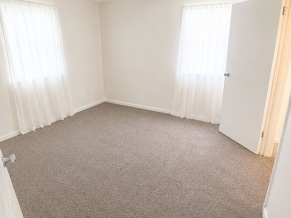 Bright and spacious private bedroom with abundant natural light and fresh carpeting.