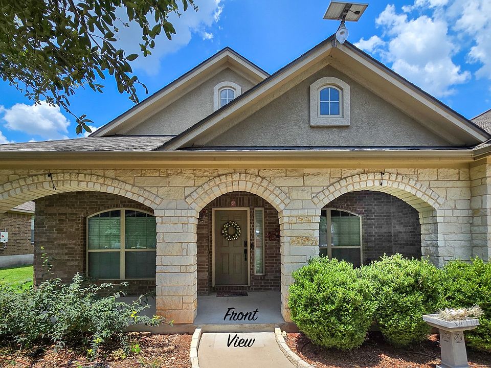 The welcoming front porch is perfect for relaxing with a morning coffee or evening glass of wine, featuring plenty of space for seating and a delightful view of the quiet, tree-lined street.