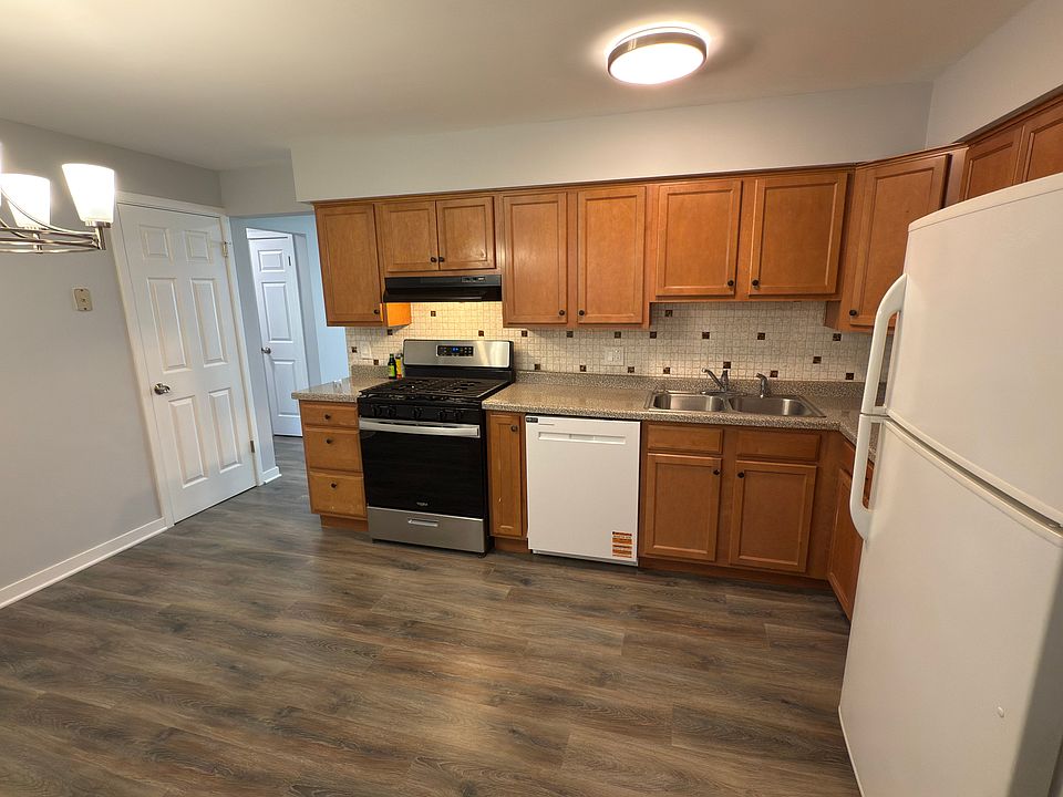 Spacious kitchen with modern vinyl plank flooring, ample cabinet storage, gas range, new dishwasher, full-size fridge.