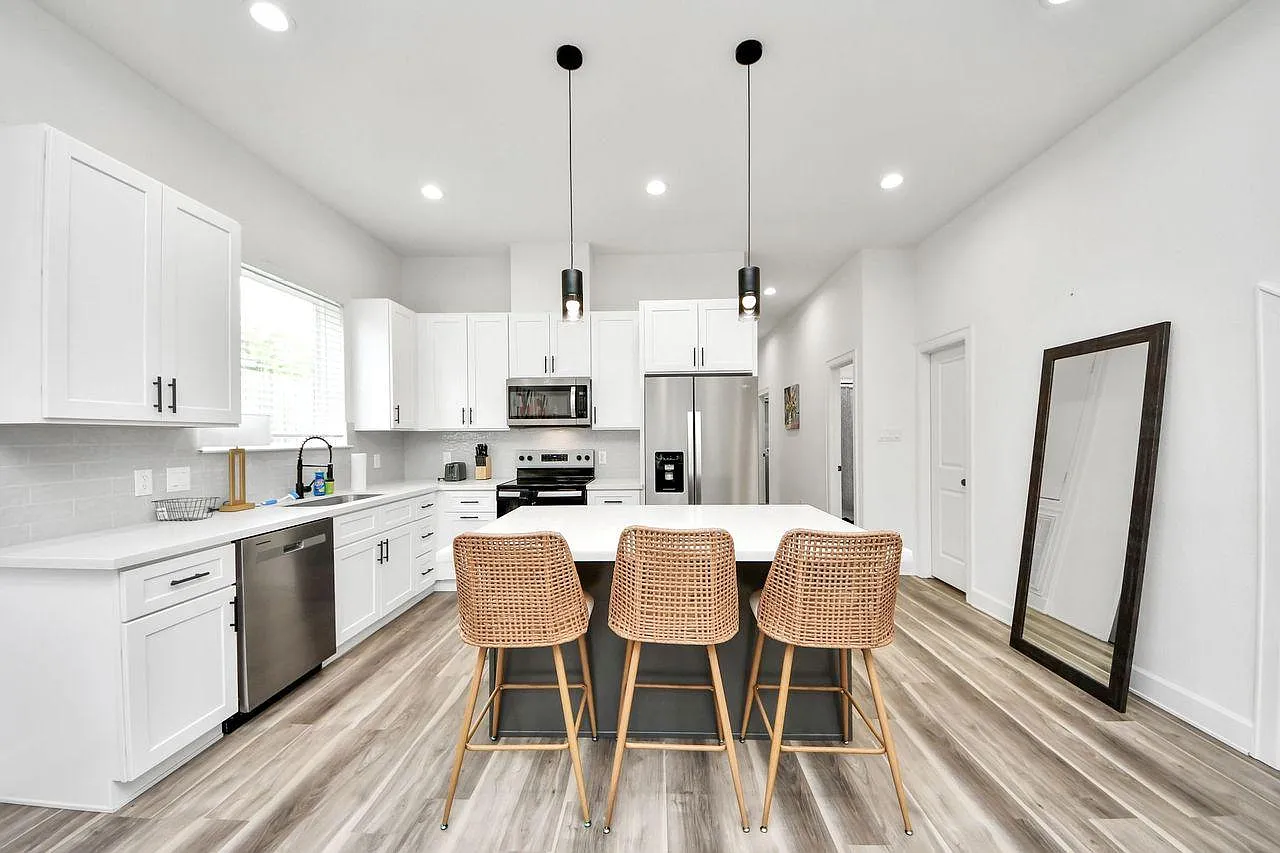 Spacious kitchen with a large island, bar seating, ample white cabinetry, and stainless-steel appliances for easy meal prep.