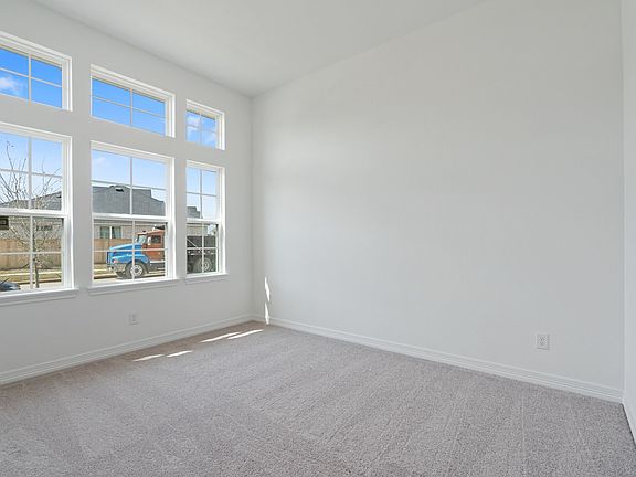 The secondary bedroom features plush carpet, fresh paint, closet, and a large window that lets in pl