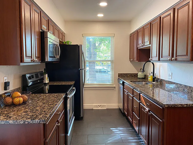 granite countertops, fully-stocked with cookware, tableware, spices and oil, full-sized fridge/freezer, electric stove and oven, microwave, and dishwasher