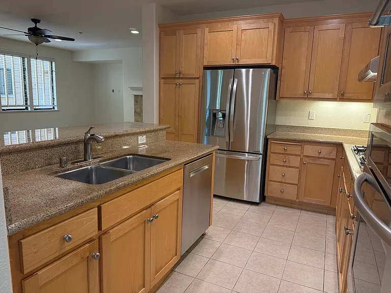 Gourmet kitchen is equipped with stainless steel appliances and soft-close cabinetry and granite countertop with a breakfast bar.